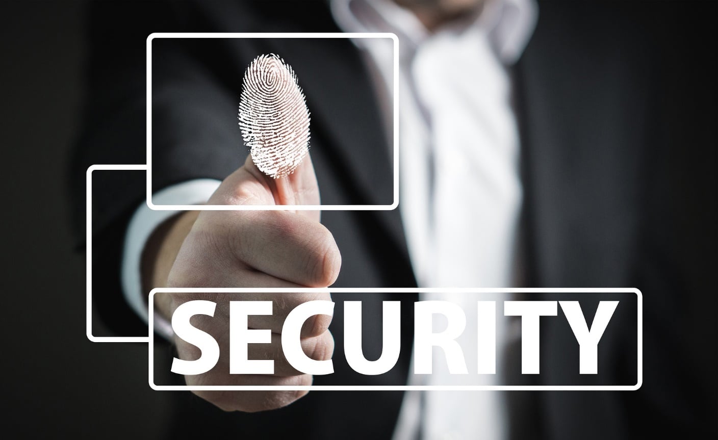 The word Security and a person using a biometric fingerprint scanner